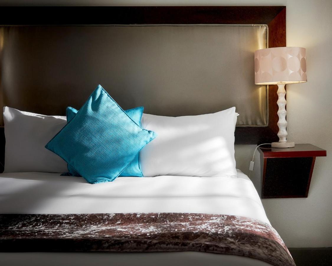 Menlyn Boutique Hotel Pretoria-Noord Exterior foto A bed with a blue throw pillow